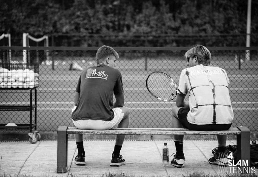 Two tennis players sitting on a bench between training sessions at 4Slam Tennis academy